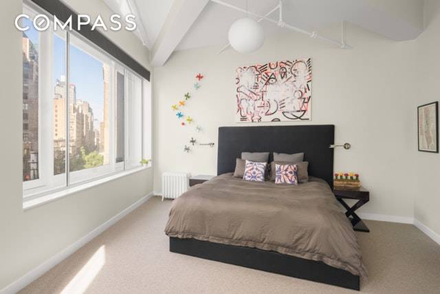 Towering 12 ceilings and a wall of oversized windows set the stage for bright and airy living spaces in this chic NoMad loft.