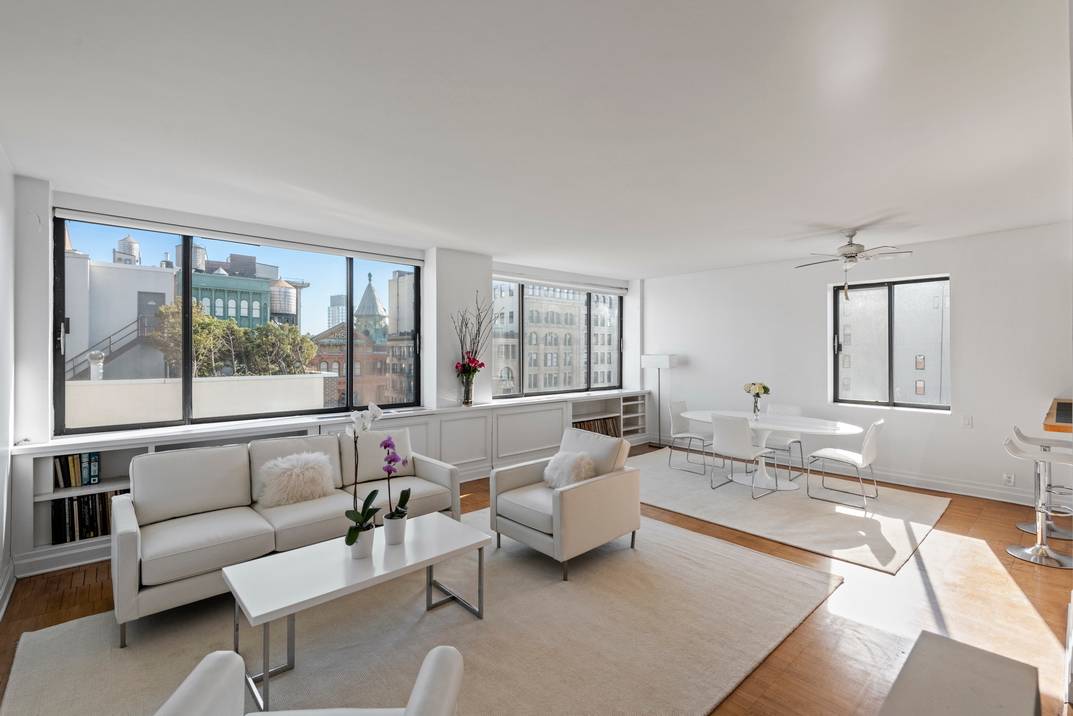 A wall of windows and stunning sky views in a sun flooded high floor two bedroom apartment in Noho/Greenwich Village