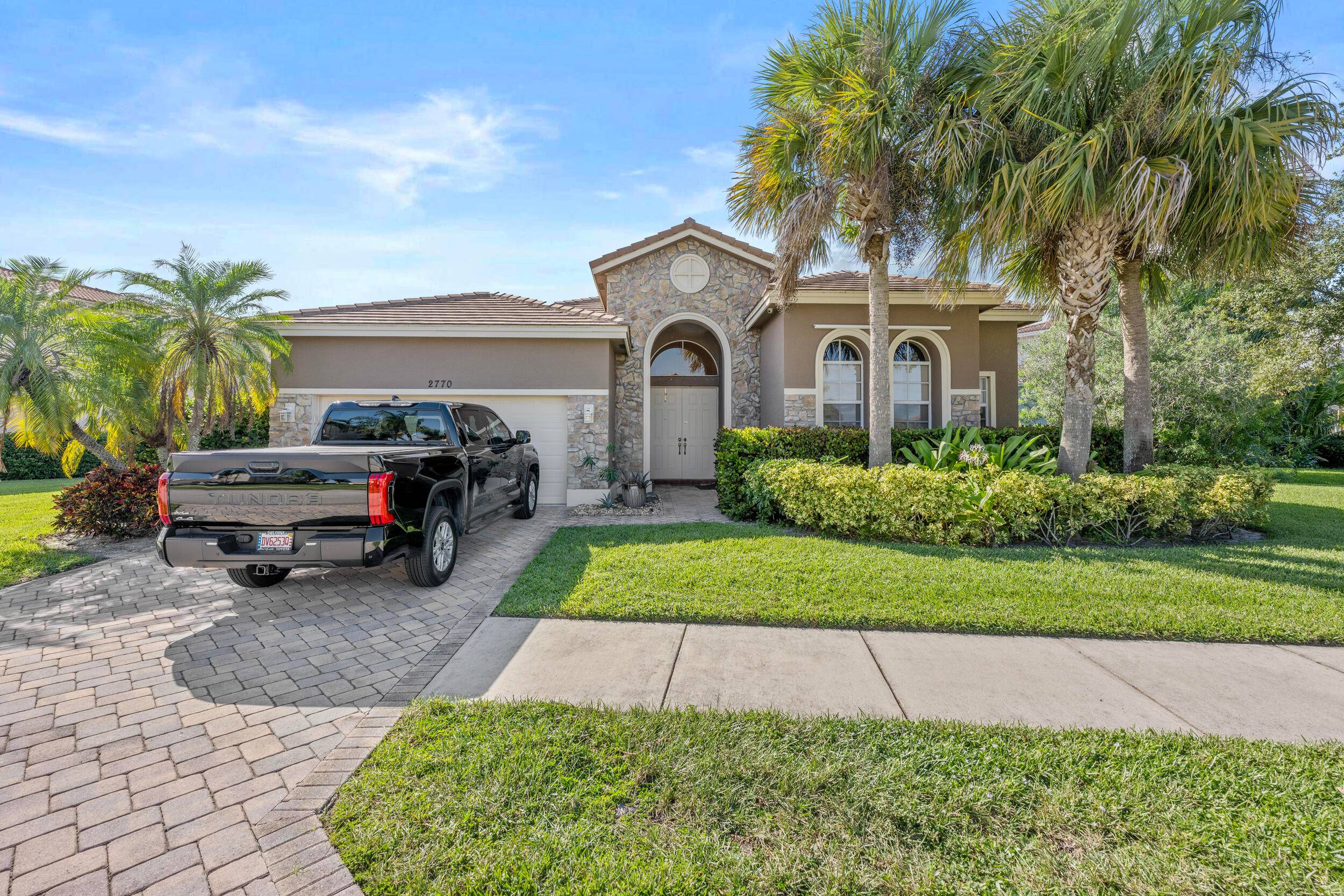 Stunning lake front Millstone Landing beauty with decorative paver driveway, stack stone exterior accents and fresh exterior paint.