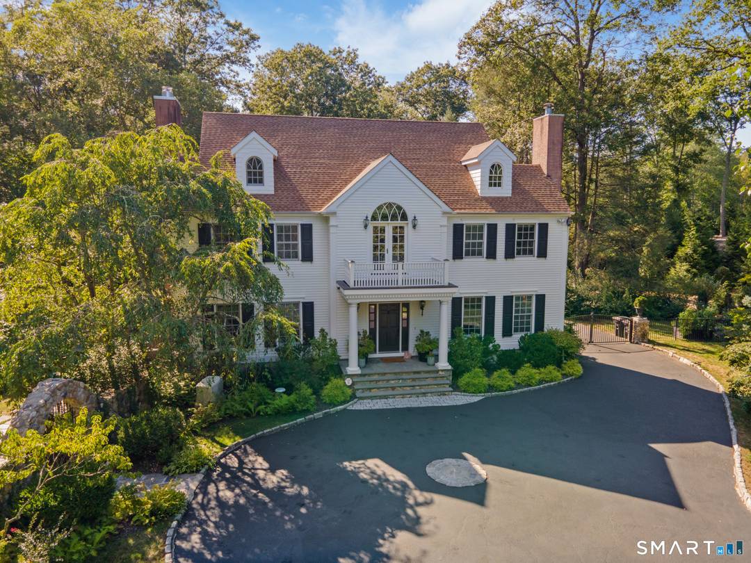 Completely and thoughtfully renovated, this exceptional New Canaan residence blends timeless architecture with refined modern luxury in a magical private setting overlooking the Noroton River and cascading waterfalls.