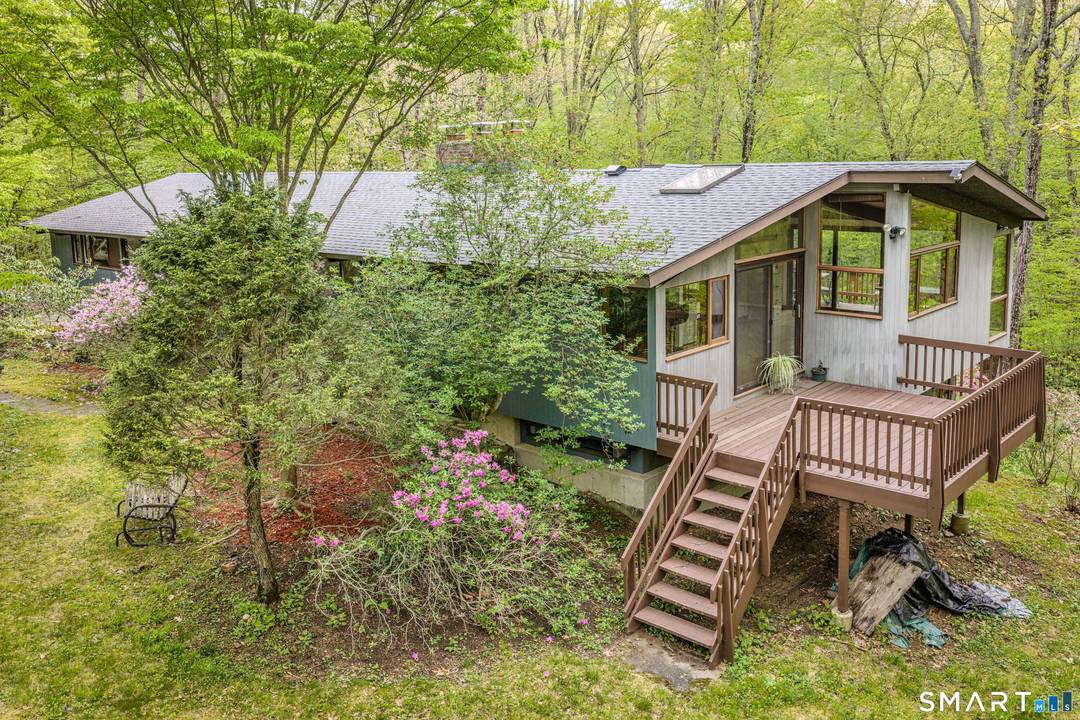 Tucked privately in the woods yet minutes from everything, this impeccably maintained Mid Century modern deck house is a rare find.
