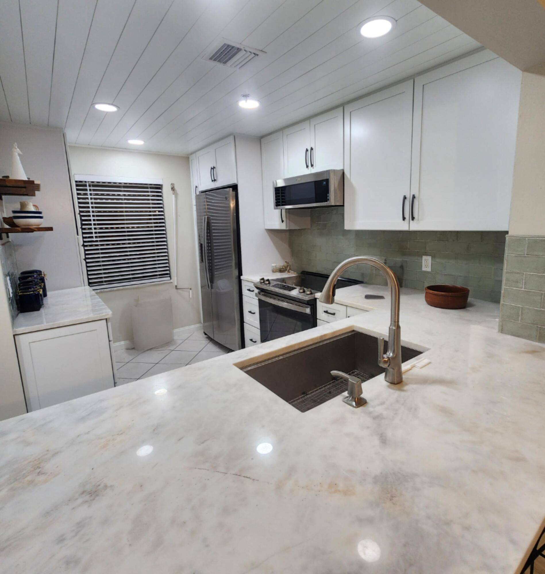 Beautifully renovated CORNER unit with distant ocean view and privacy of State Preserve on north side !