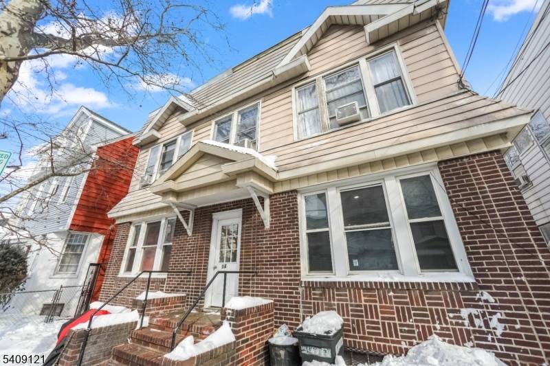 Huge and well maintained 4 unit side by side duplex featuring a classic, symmetrical facade with brick on the first level and durable siding above.