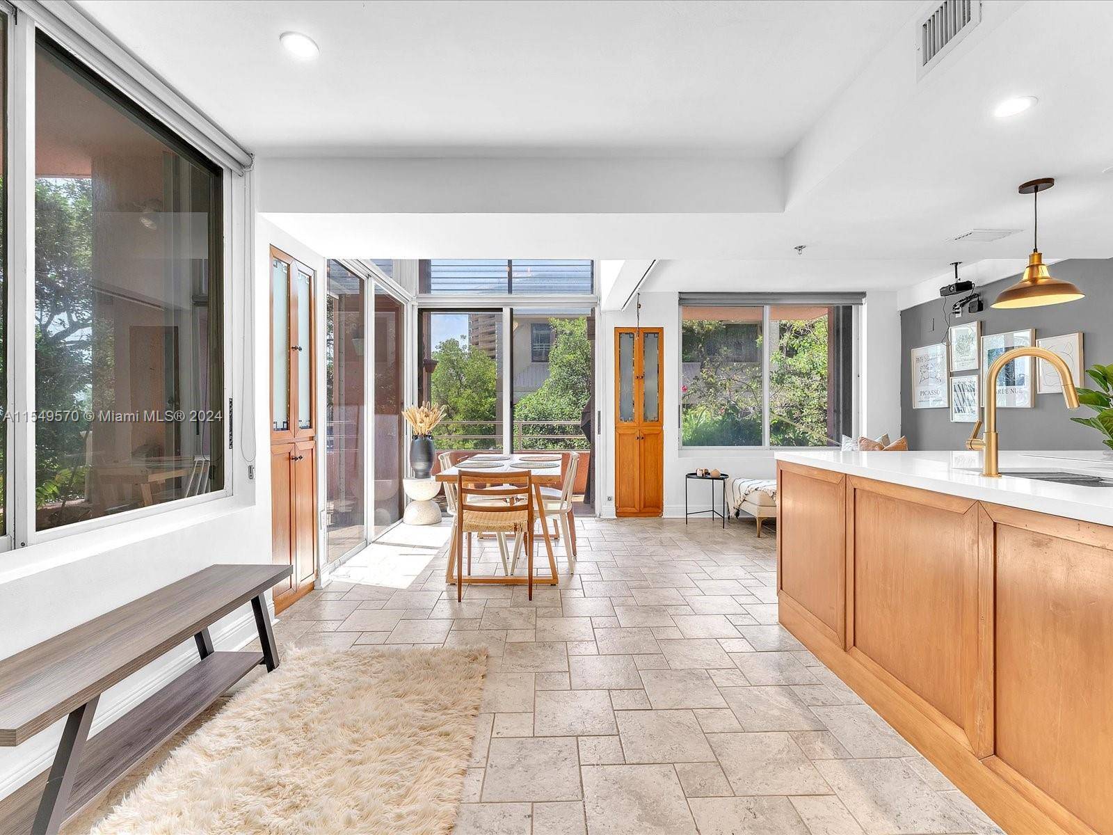 This sunlit corner unit is a sanctuary, featuring a renovated open kitchen with chic white quartz and modern appliances, and A C, all under 3 years old.