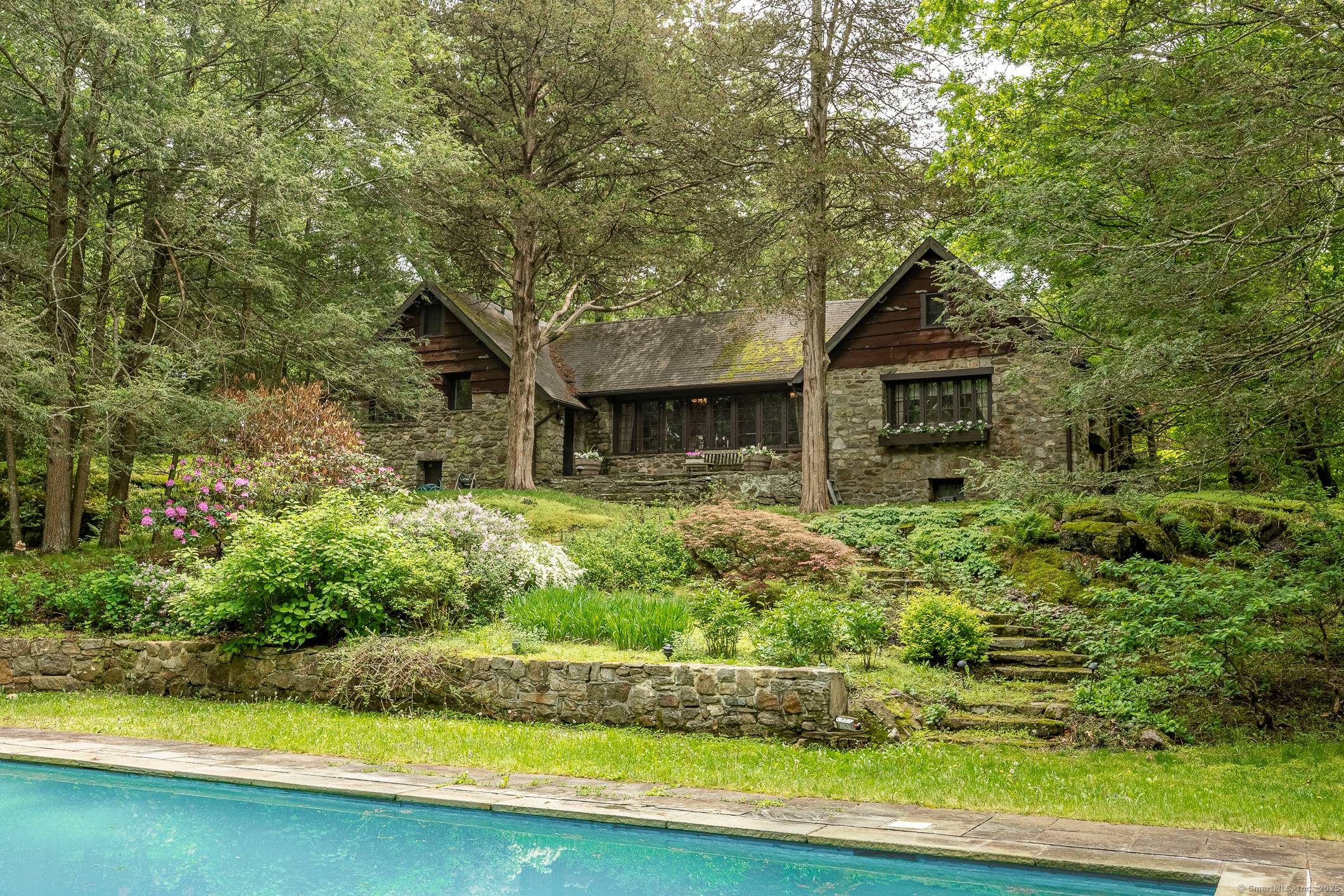 1930's Story Book Cottage exuding charm and period details, privately located down a long tree lined driveway on 10 lush acres with a fabulous heated, saltwater pool.