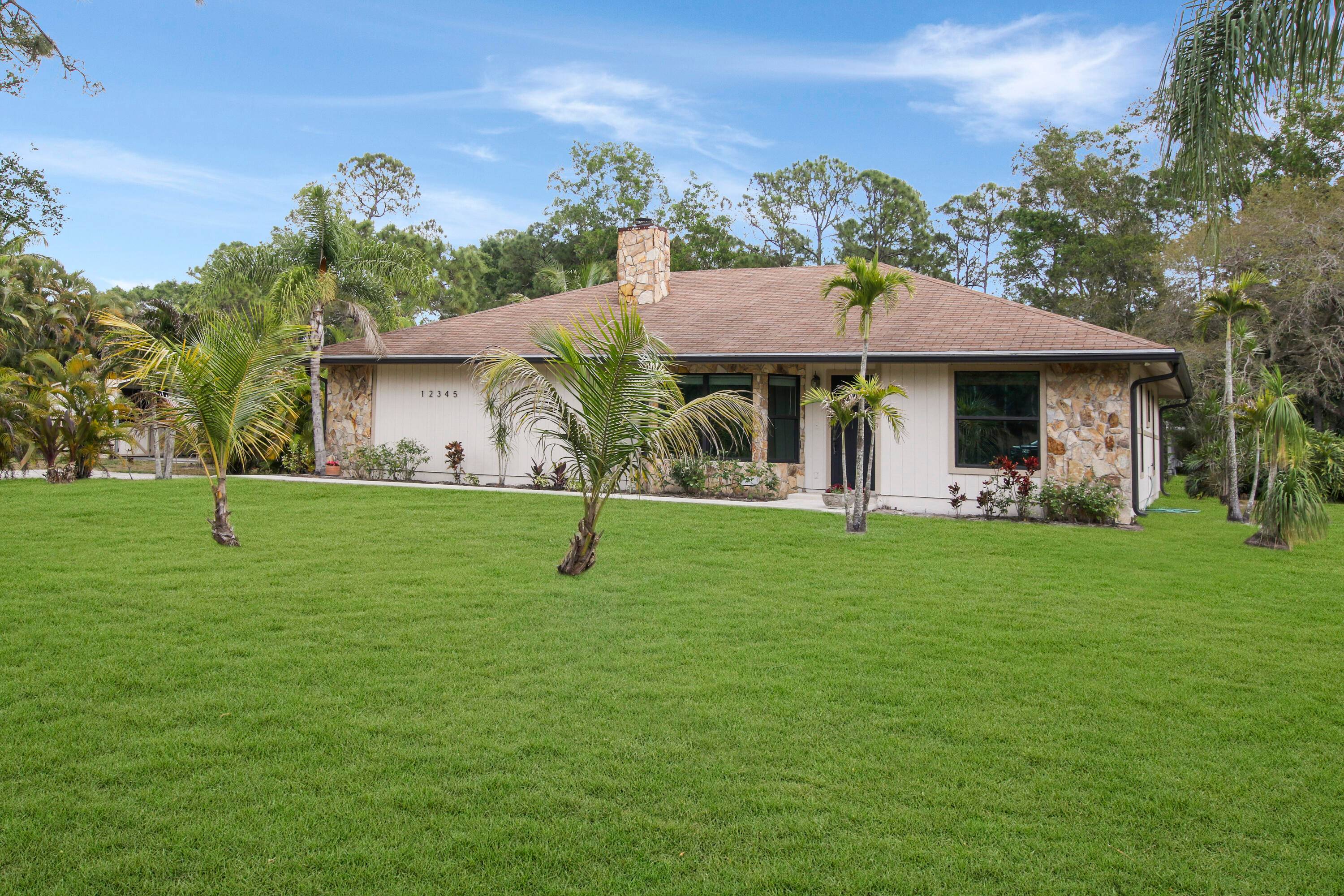 Lovely Jupiter Farms home on a desirable corner lot, paved road on both streets with a treelined sidewalk.
