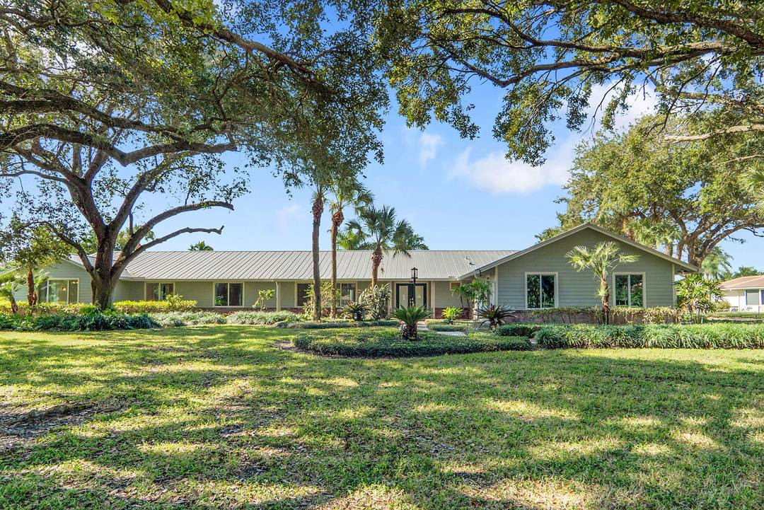 BEAUTIFUL RANCH STYLE 4 BEDROOM 3 BATH HOME PLUS OFFICE DEN AND BONUS FLORIDA ROOM WITH GORGEOUS WIDE LAKE VIEWS ON A 1.