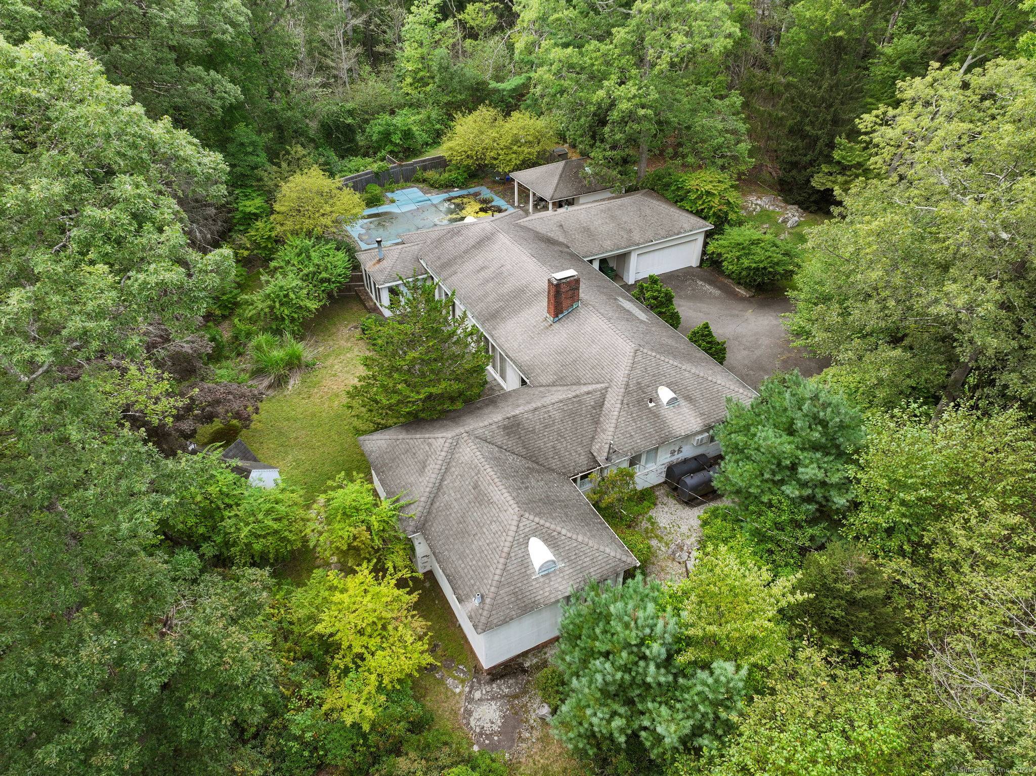 Mid century modern ranch with in ground pool, pool house and two additional out buildings.