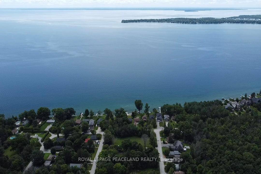 Unveil the enchantment of a charming lakeside retreat where a captivating all brick beauty awaits mere steps from the shimmering lake.