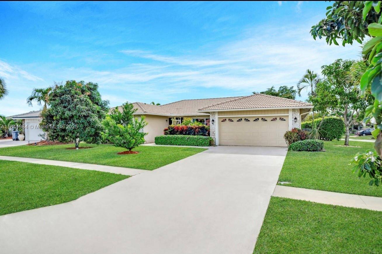 Renovated Corner Lot Home with 3 Bedrooms, 2 Baths, 2 Car Garage, Pool, and Lake Views in the prestigious Boca Greens Country Club a gated golf community.