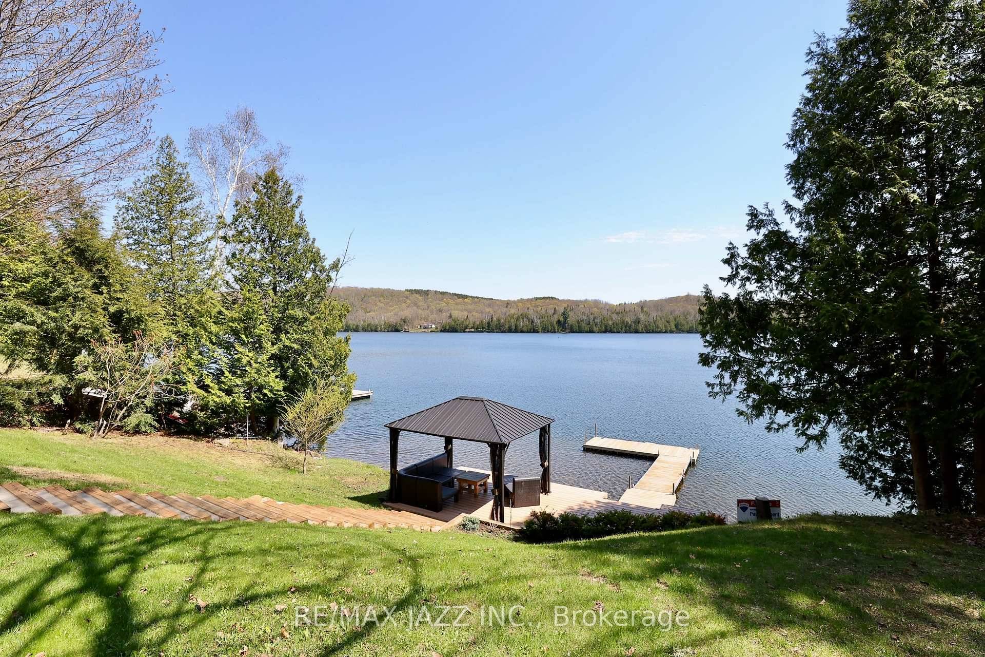 Imagine a charming lakeside cottage retreat nestled on a generous expanse of land, offering panoramic views of a sparkling, pristine lake.