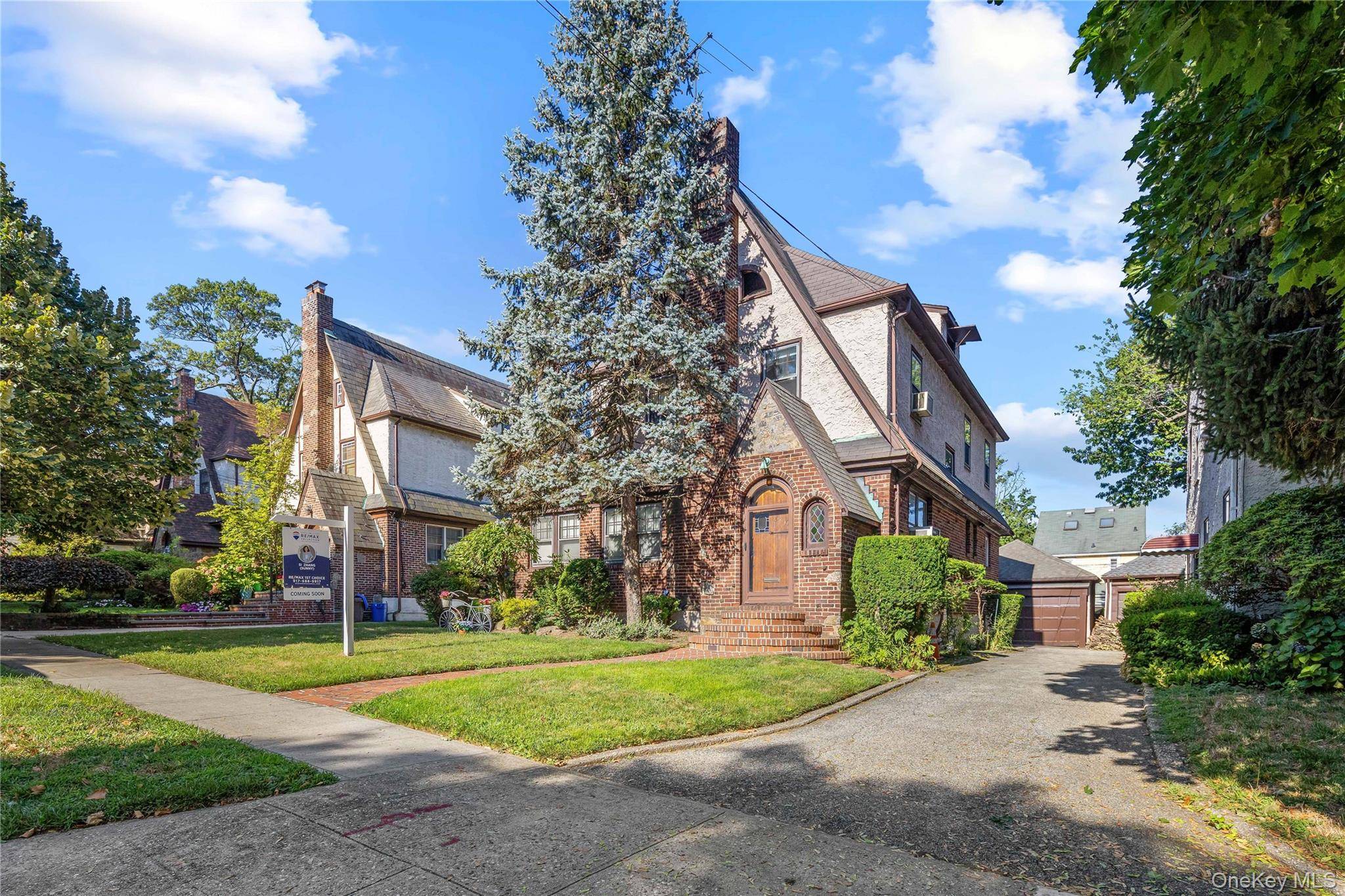 This ultra handsome, true brick and fieldstone Tudor is surrounded by lovely, lush trees, featuring a charming front entrance.