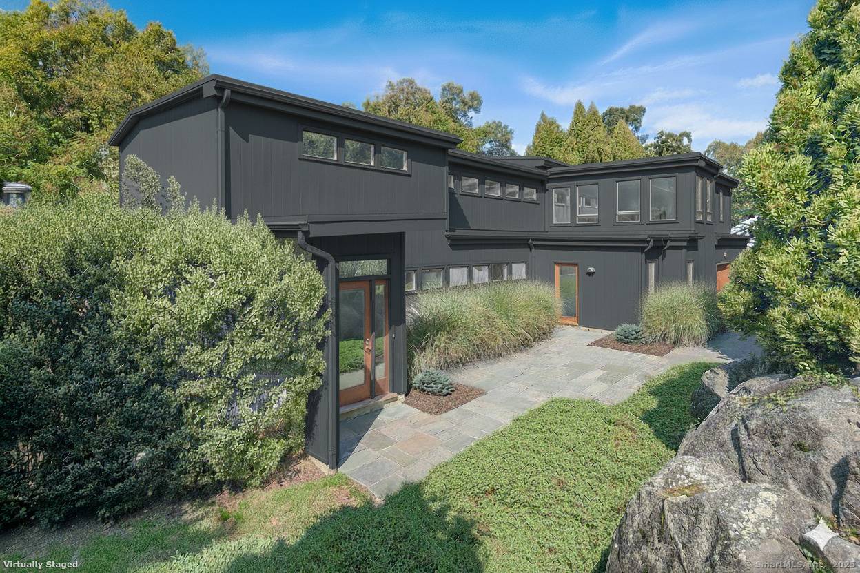 Perched high above the Goodwives River, this stunning Mid Century Modern home offers sophisticated living in an extraordinary natural setting.