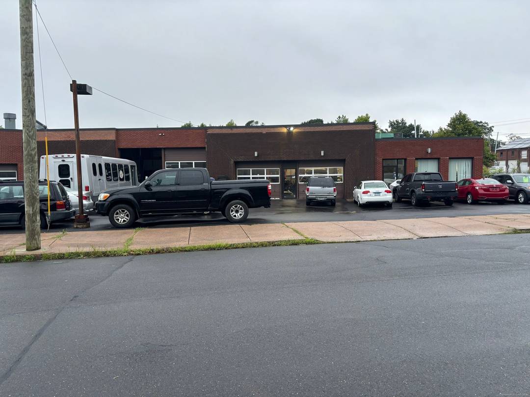 Expansive 11 bay building that currently houses an auto repair auto body shop and licensed car dealership.