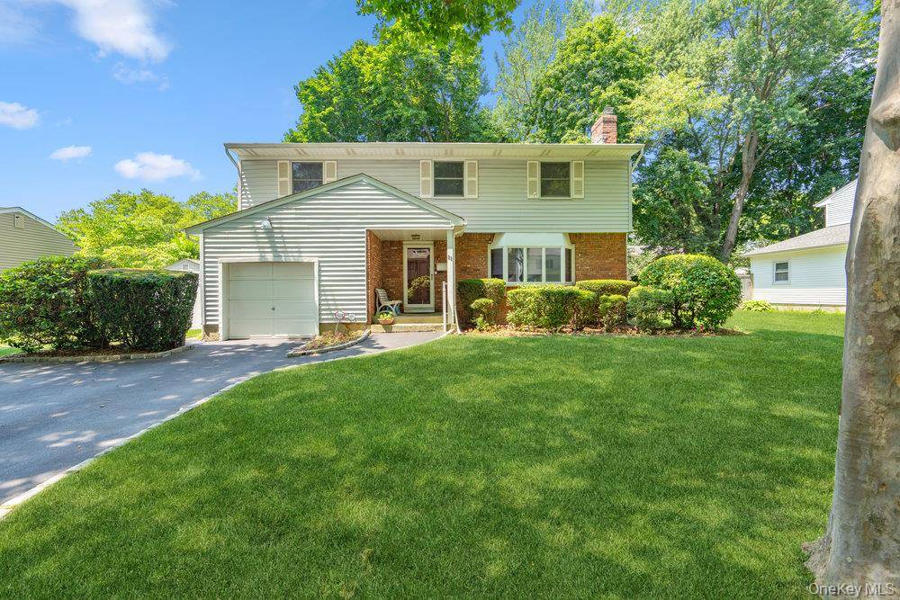 Spacious Colonial featuring a sunken living room with a wood burning fireplace, formal dining room, eat in kitchen, and an extended family room with a half bath and direct access ...