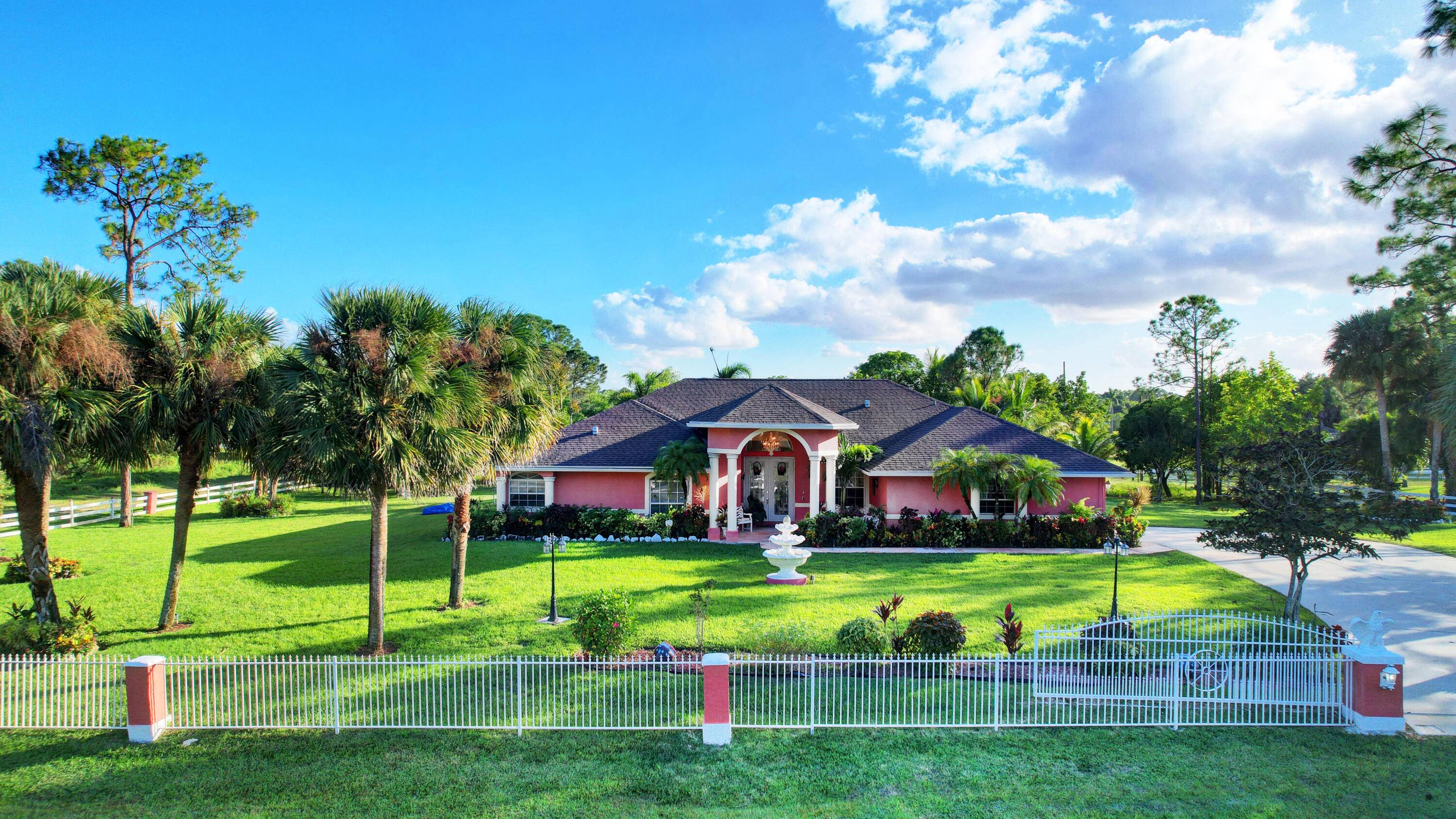 Stunning single story residence nestled on a private, gated 1 acre lot in Loxahatchee FL.