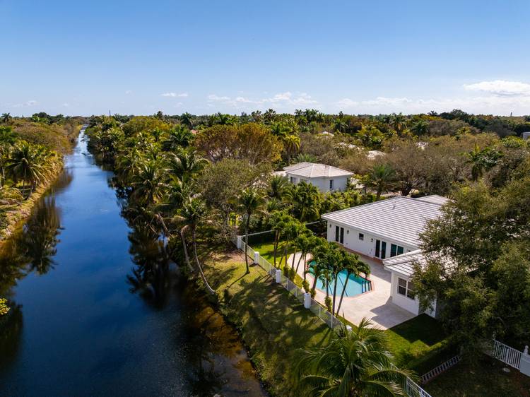 Nestled in one of Pinecrest's most coveted gated communities, this nearly 4, 000 SF, fully renovated 4 bedroom, 3 bath residence offers effortless luxury and serene canal front living.