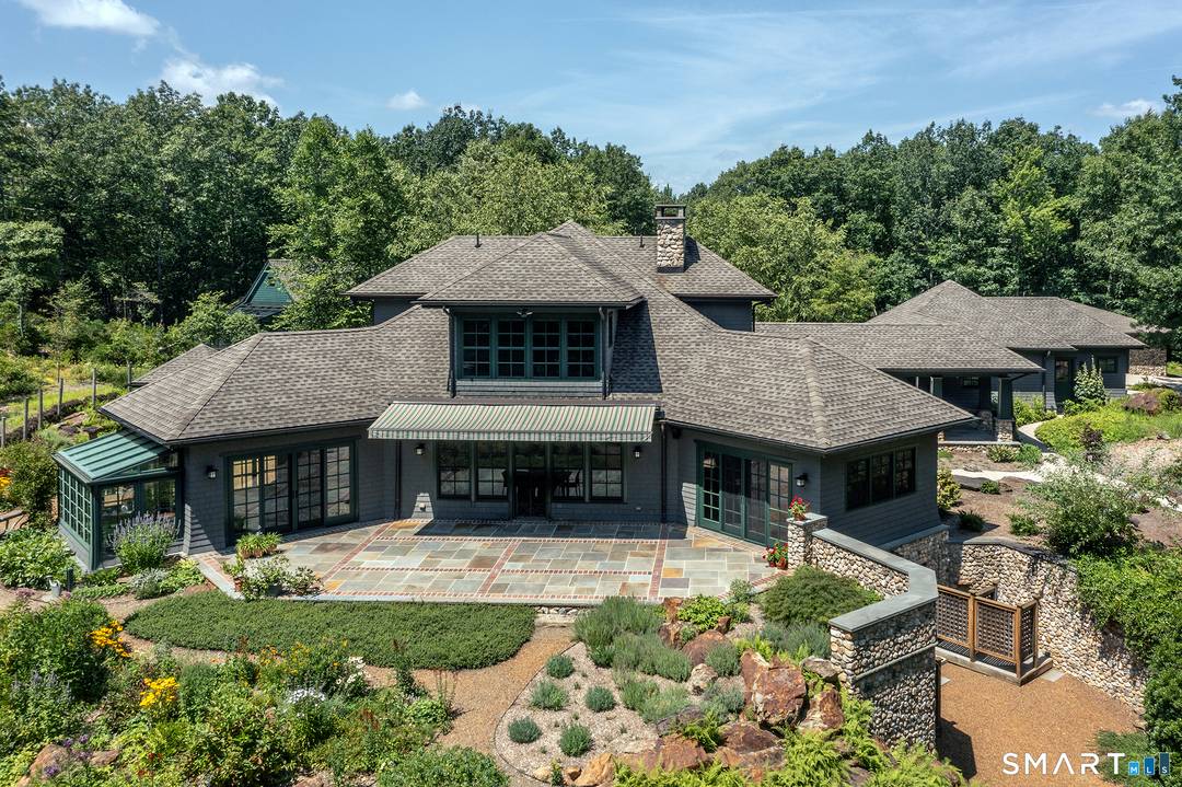 Tucked along Big Cove on Lake Quassapaug, this custom architect designed Arts Crafts bungalow is privately set on 14.