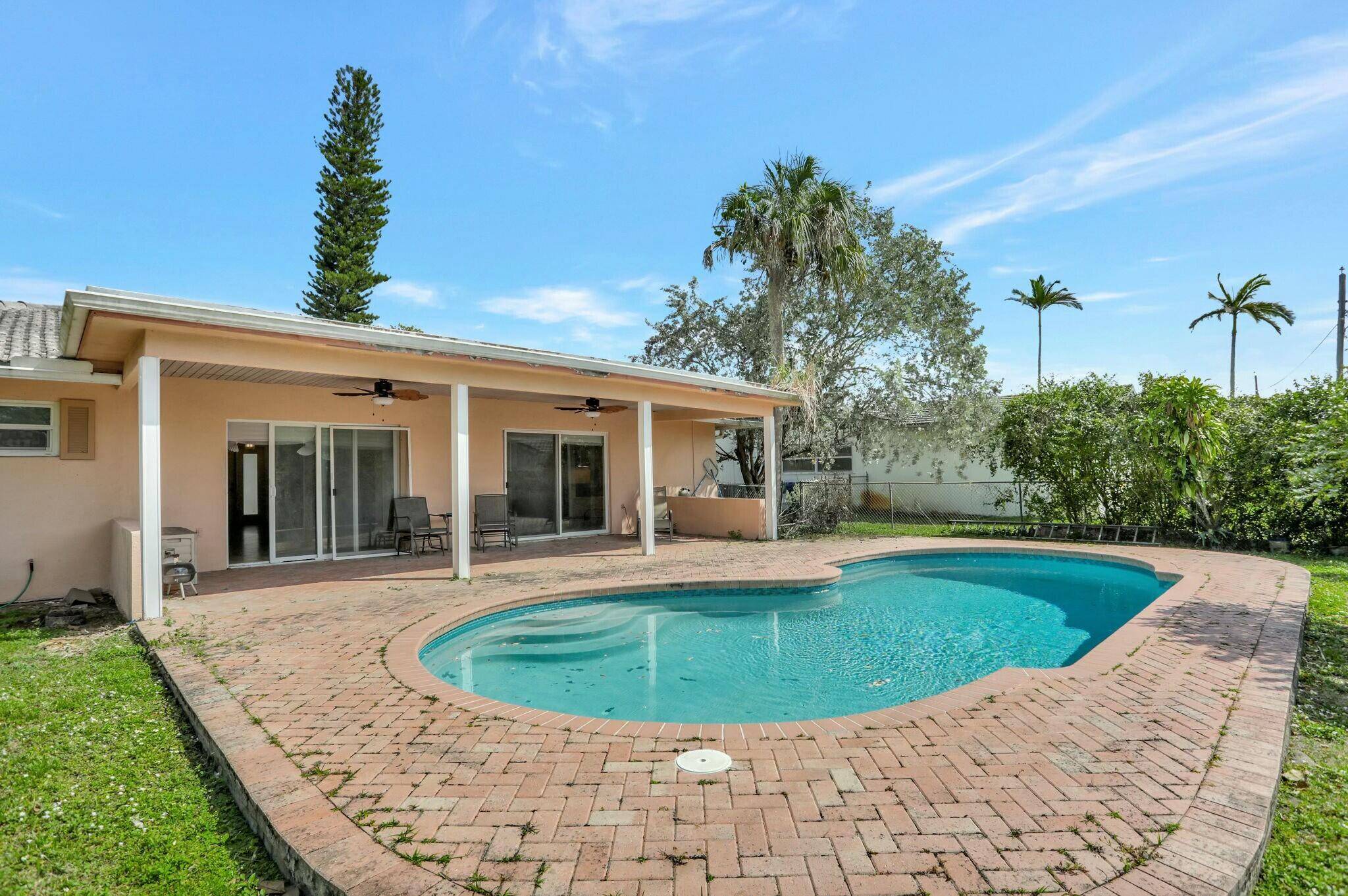 This pool home features an open floor plan with impact resistant windows and doors, granite countertops, and stainless steel appliances.