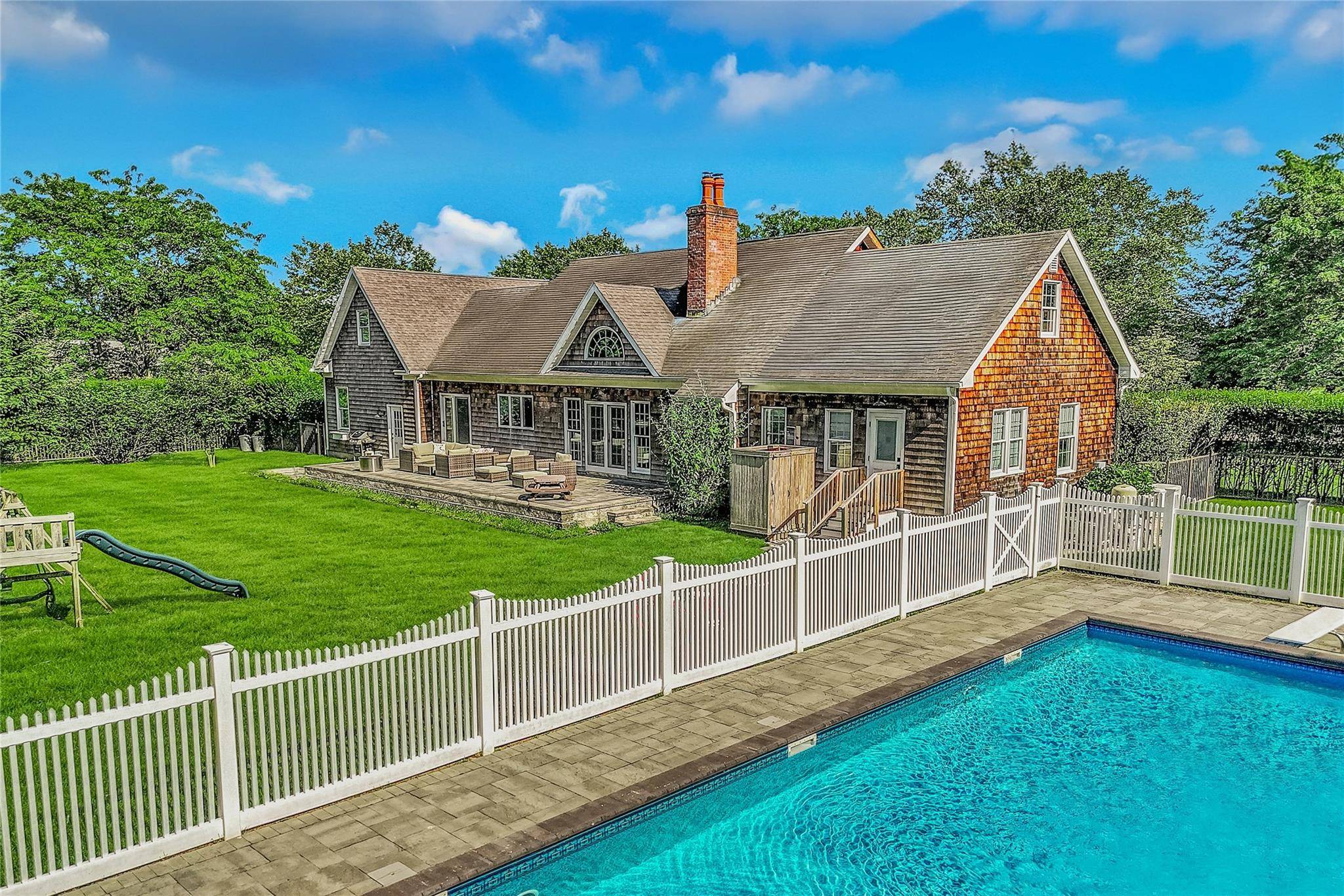 Discover the allure of North Fork living in this charming cedar shake home nestled within the coveted Fairway Farms community of Cutchogue.
