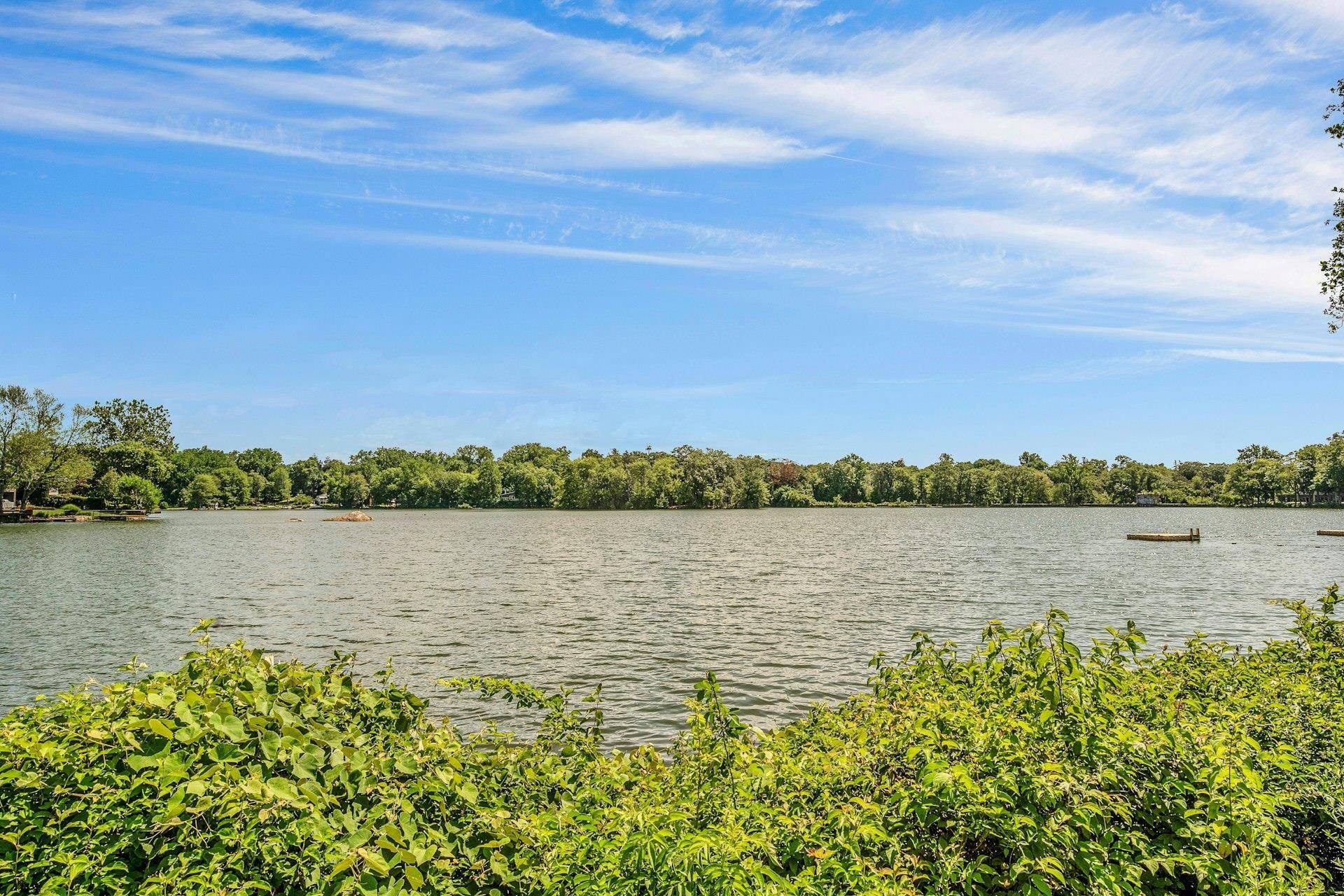 Enjoy tranquil lake views and sun filled spaces in this charming first floor, 2 bedroom simplex unit directly across from the picturesque Lake Innisfree.
