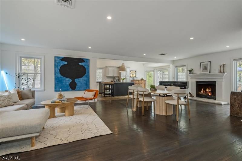 Flooded with natural light, the heart of this midcentury Colonial is an expansive, open concept living space w separate formal LR.