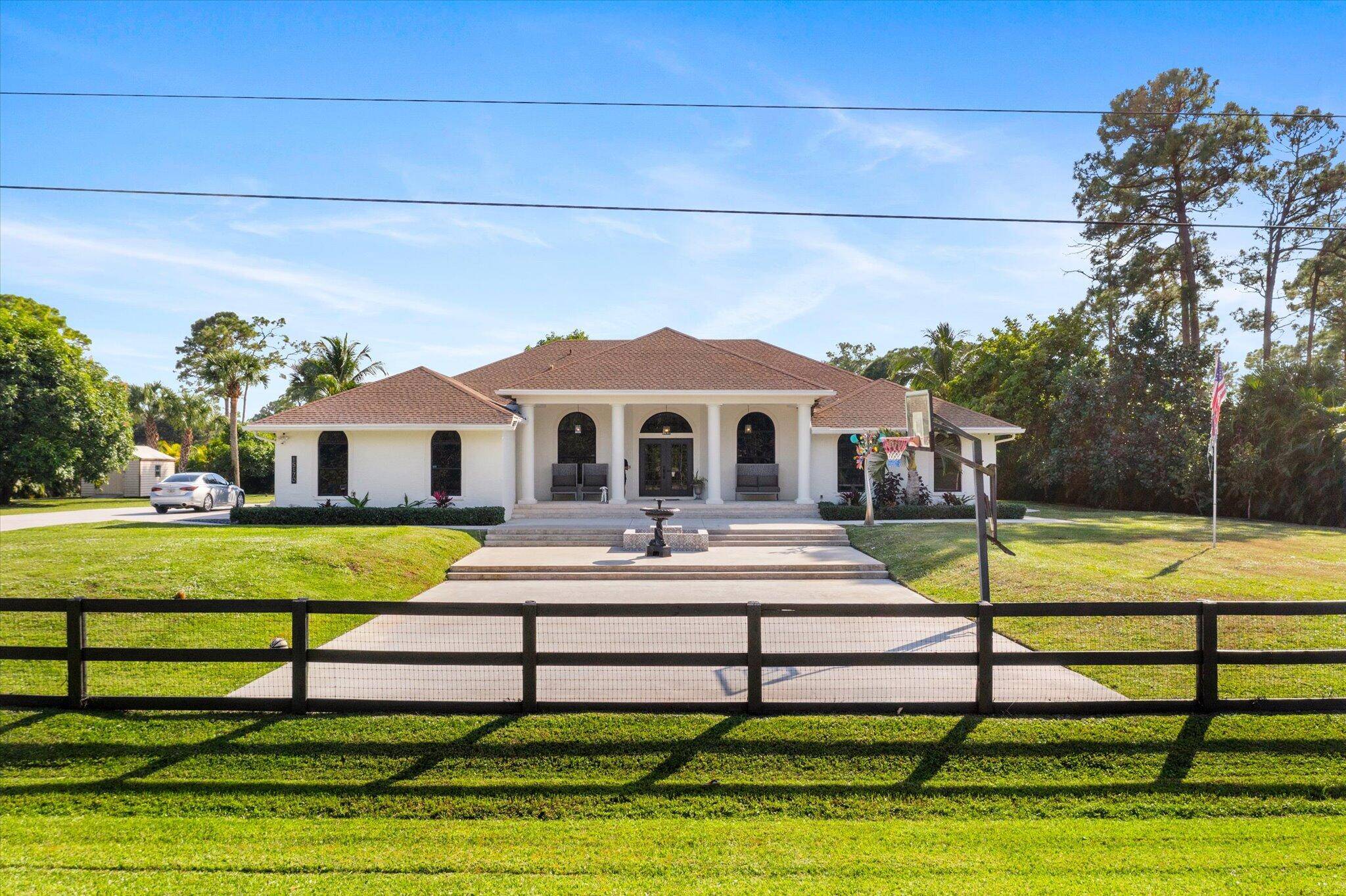 Perfectly Located on the North end of The Acreage on a paved road, fully fenced with gated entry, right off of Northlake Blvd, this exquisite 1.