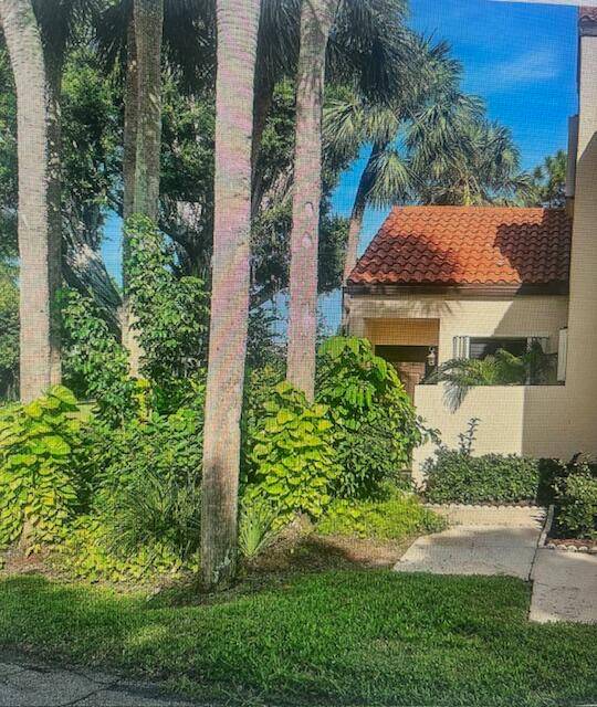 Beautiful first floor desirable 2 bedroom 2 bathroom super private end unit ''villa'' ON THE LAKE in gorgeous landscaped ''Dos Lagos'' community in Boynton Beach !