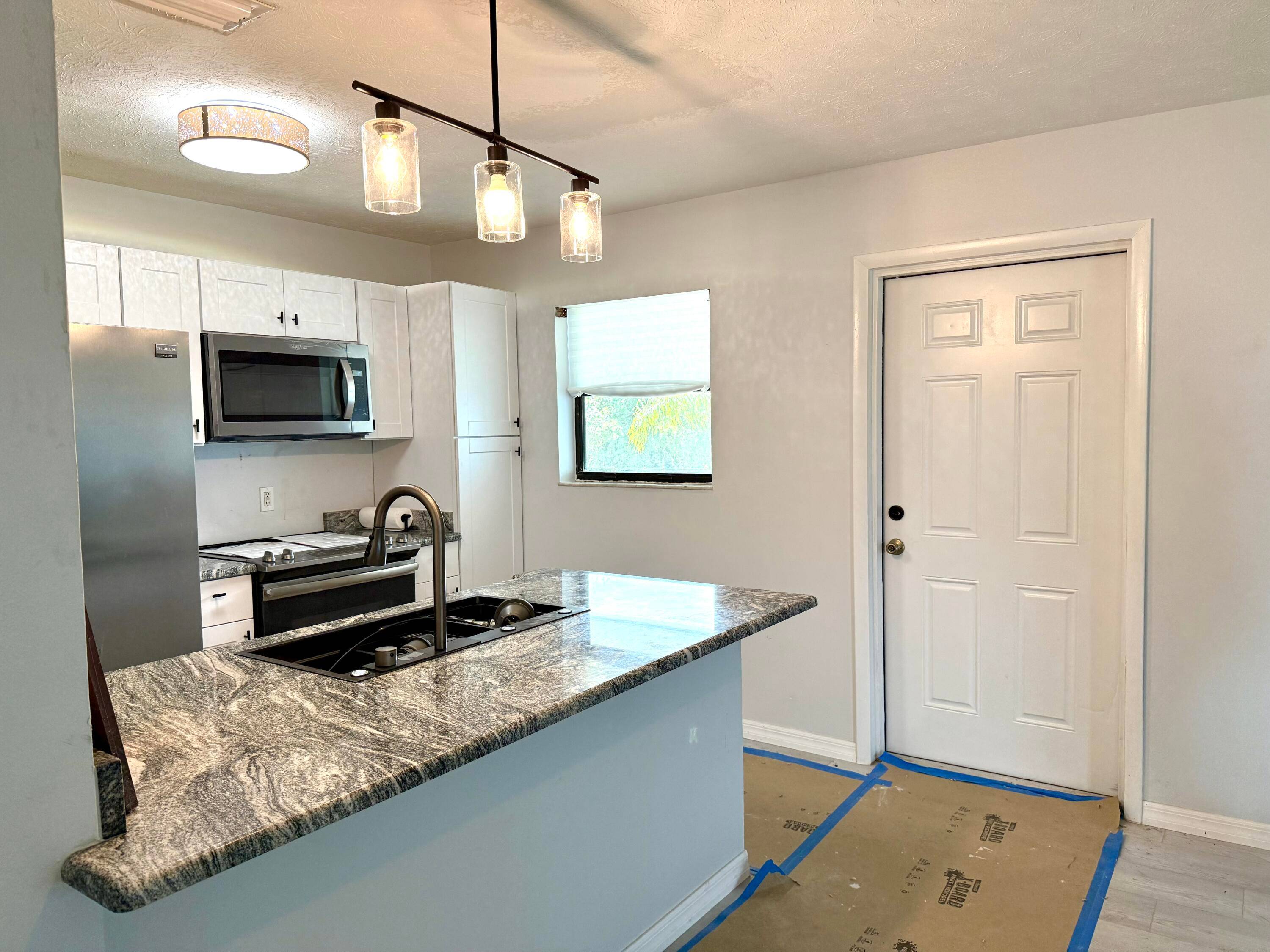 Completely renovated upper unit with new waterproof laminate floors and shaker cabinets, granite countertops open to bar living area.