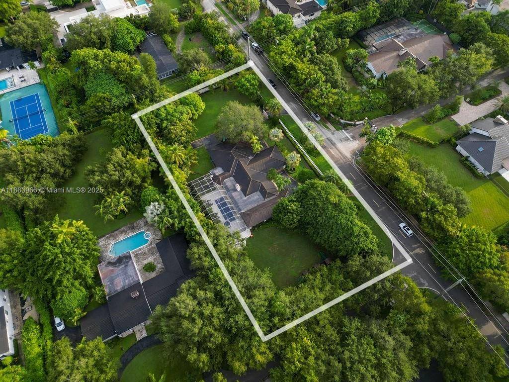Nestled on over an acre in sought after NE Pinecrest, this property is situated on a corner lot with a surrounding perimeter wall.