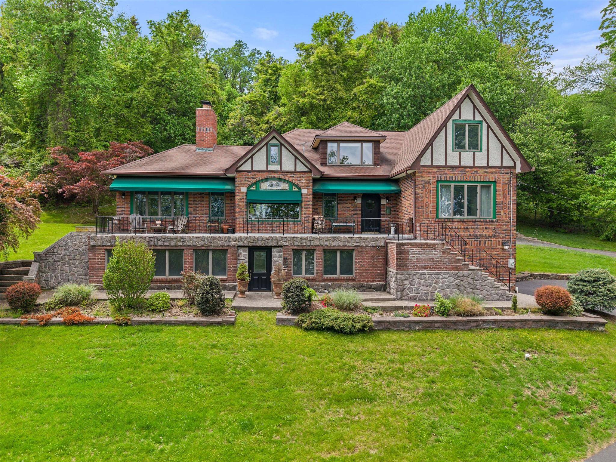 Nestled on 4. 4 serene, wooded acres in Upper Grandview, New York, this distinguished 1920s Tudor blends rich history with modern comfort.