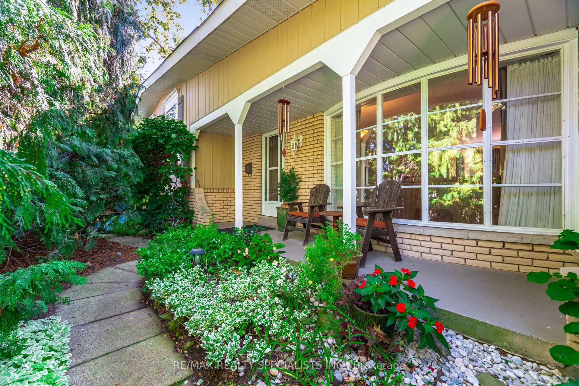 A rare garden sanctuary with multiple enclosed sunrooms and several distinct outdoor living areas.
