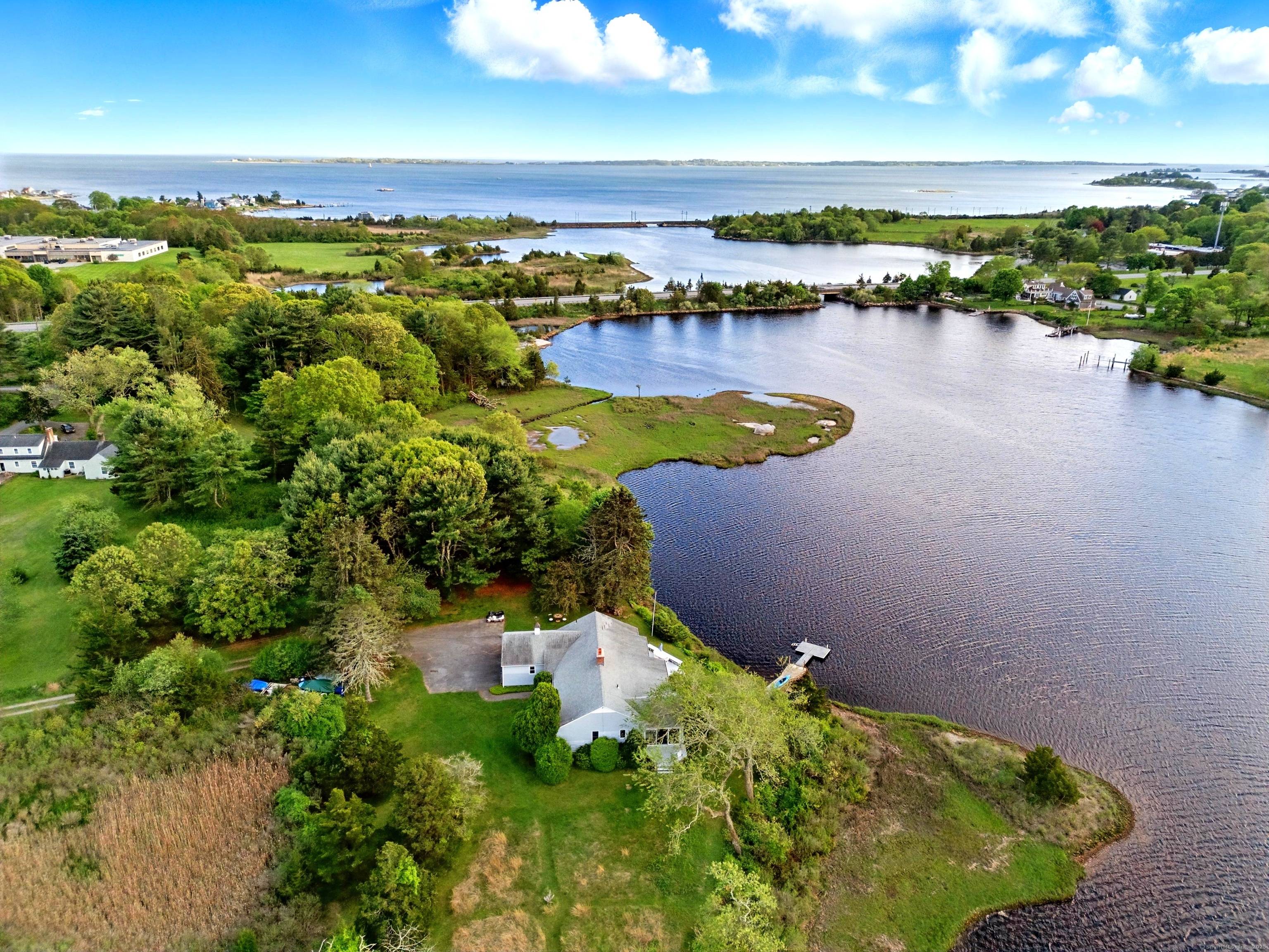 Experience peaceful privacy on over two acres of stunning water frontage on a private road, moments away from the charming downtown Mystic Stonington.
