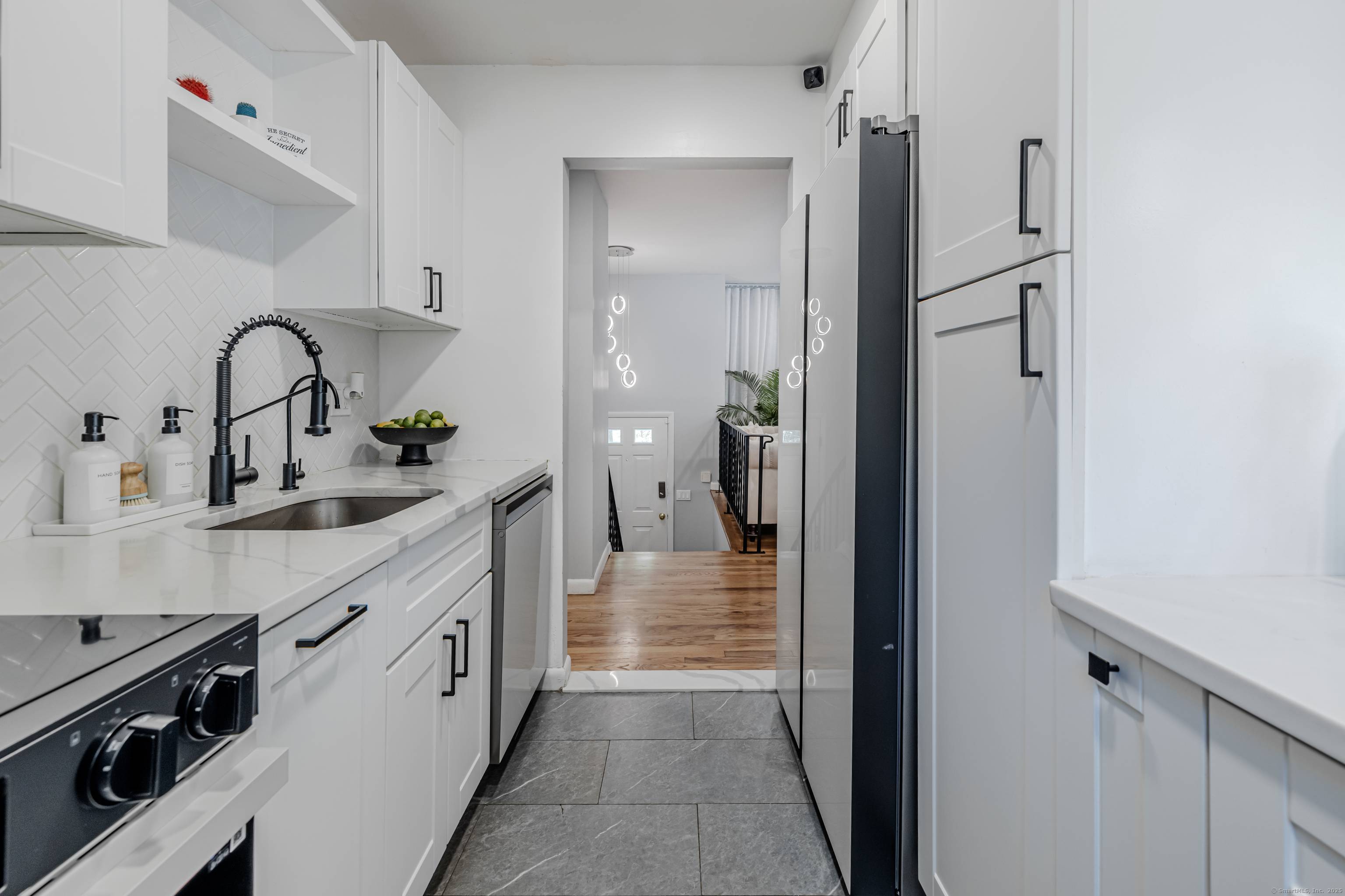 Beautifully renovated 3BR 2BA Raised Ranch featuring gleaming hardwood floors throughout the living room, dining area, hallway, and bedrooms.