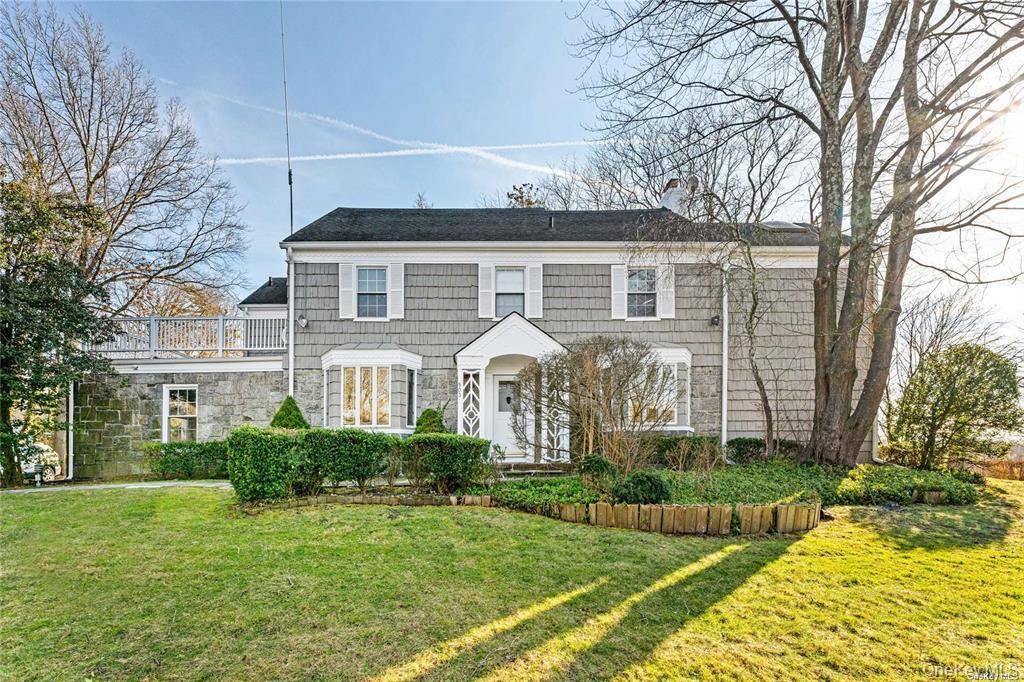 Woodsburgh Corner home located on a hill overlooking a golf course and water.