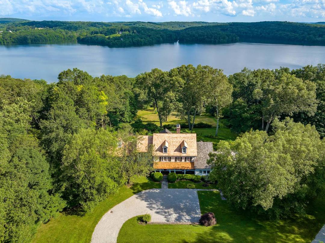 Capturing a spectacular 180 degree view of the Titicus Reservoir, this modern farmhouse is set atop 49 acres.