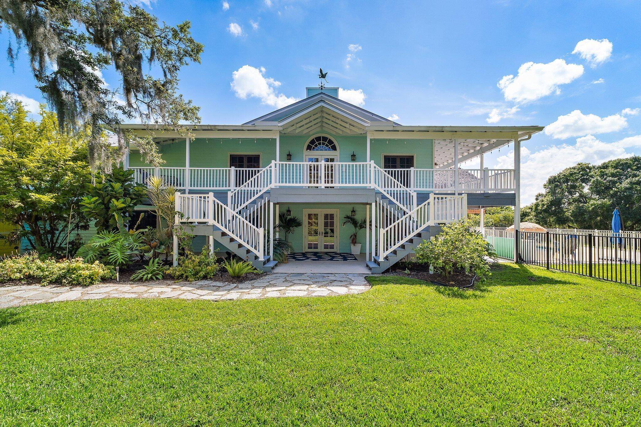 Experience luxury living in this stunning Key West style estate on over 2 private acres !
