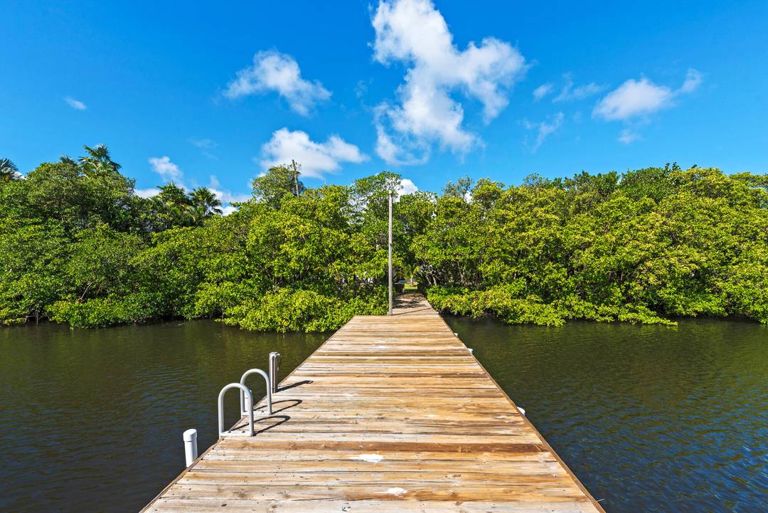 Boasting direct Intracoastal bliss, this charming 4br home is nestled on a quiet street, with mature, lush landscaping.