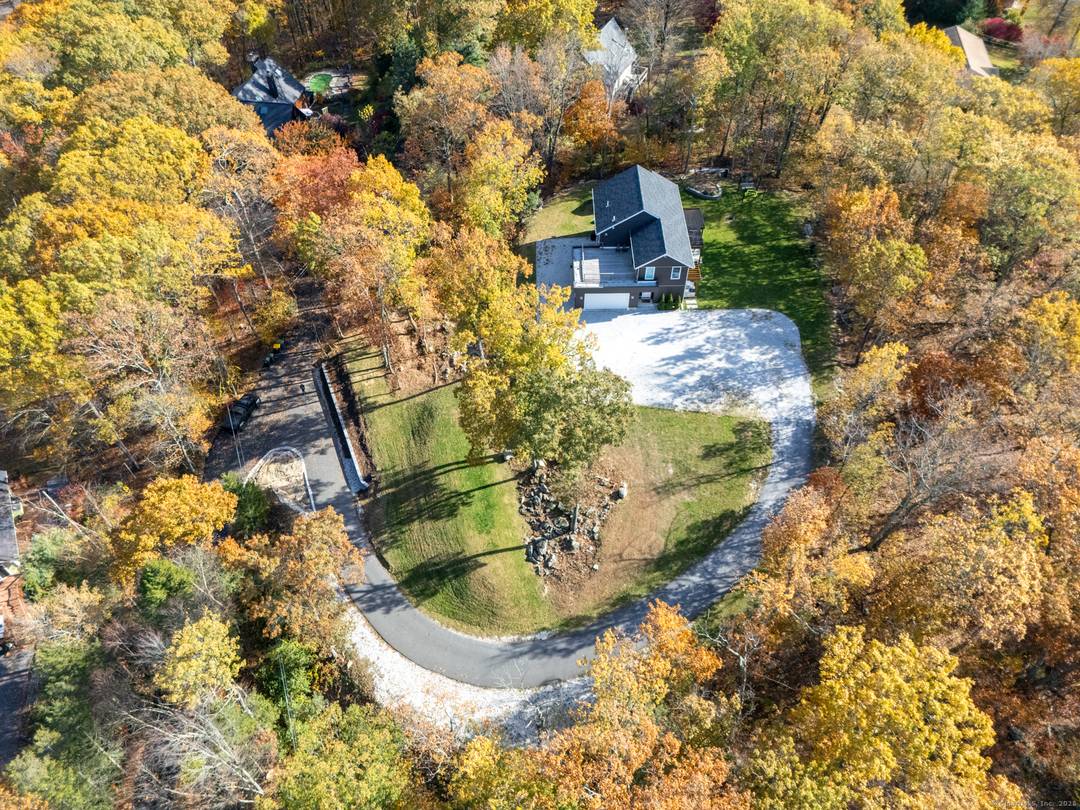 Modern 2020 built home set on a private, wooded acre with a long driveway and open lawn space.