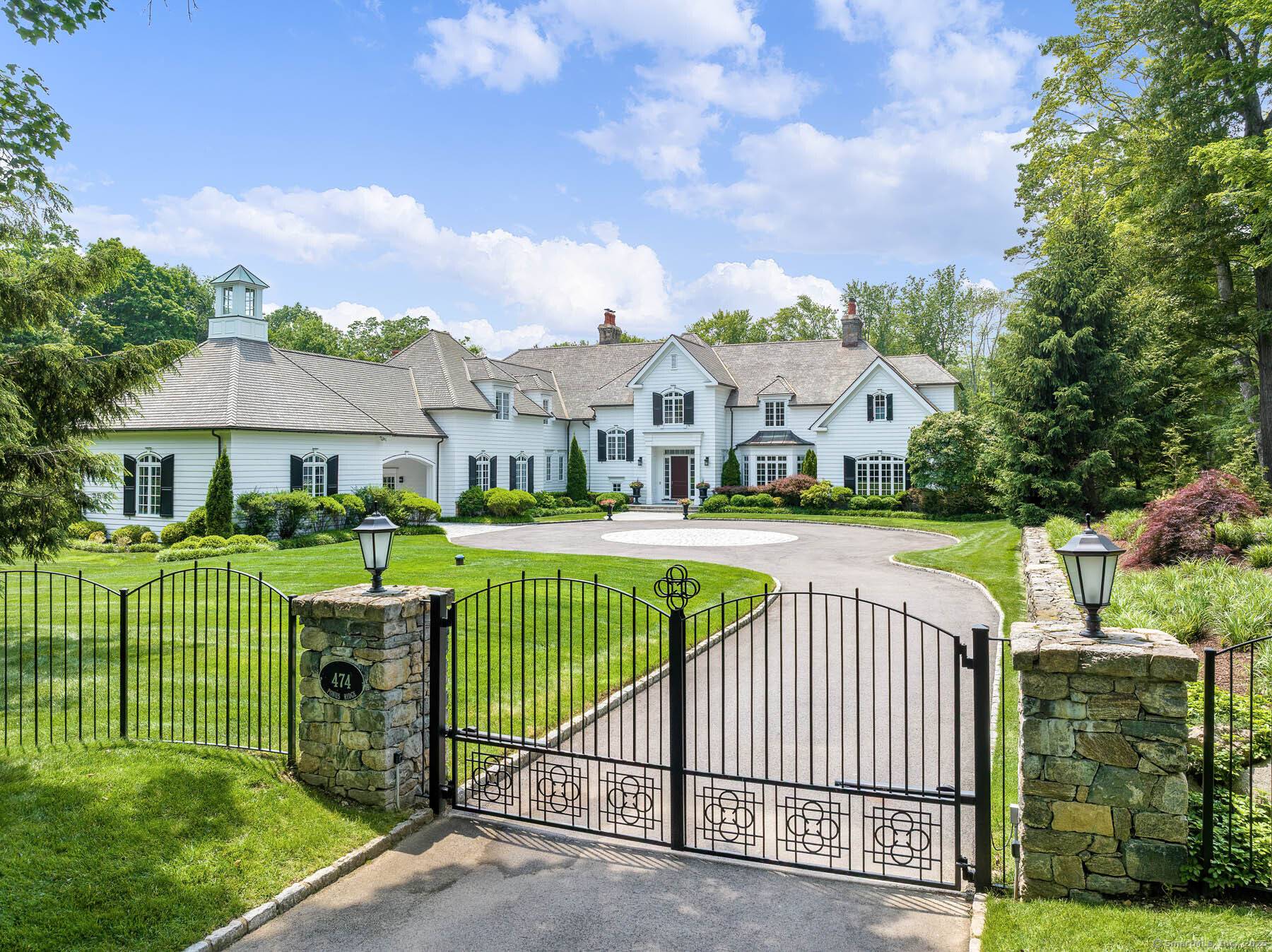 Discover elegance at this custom stone and shingle French Colonial on 4.