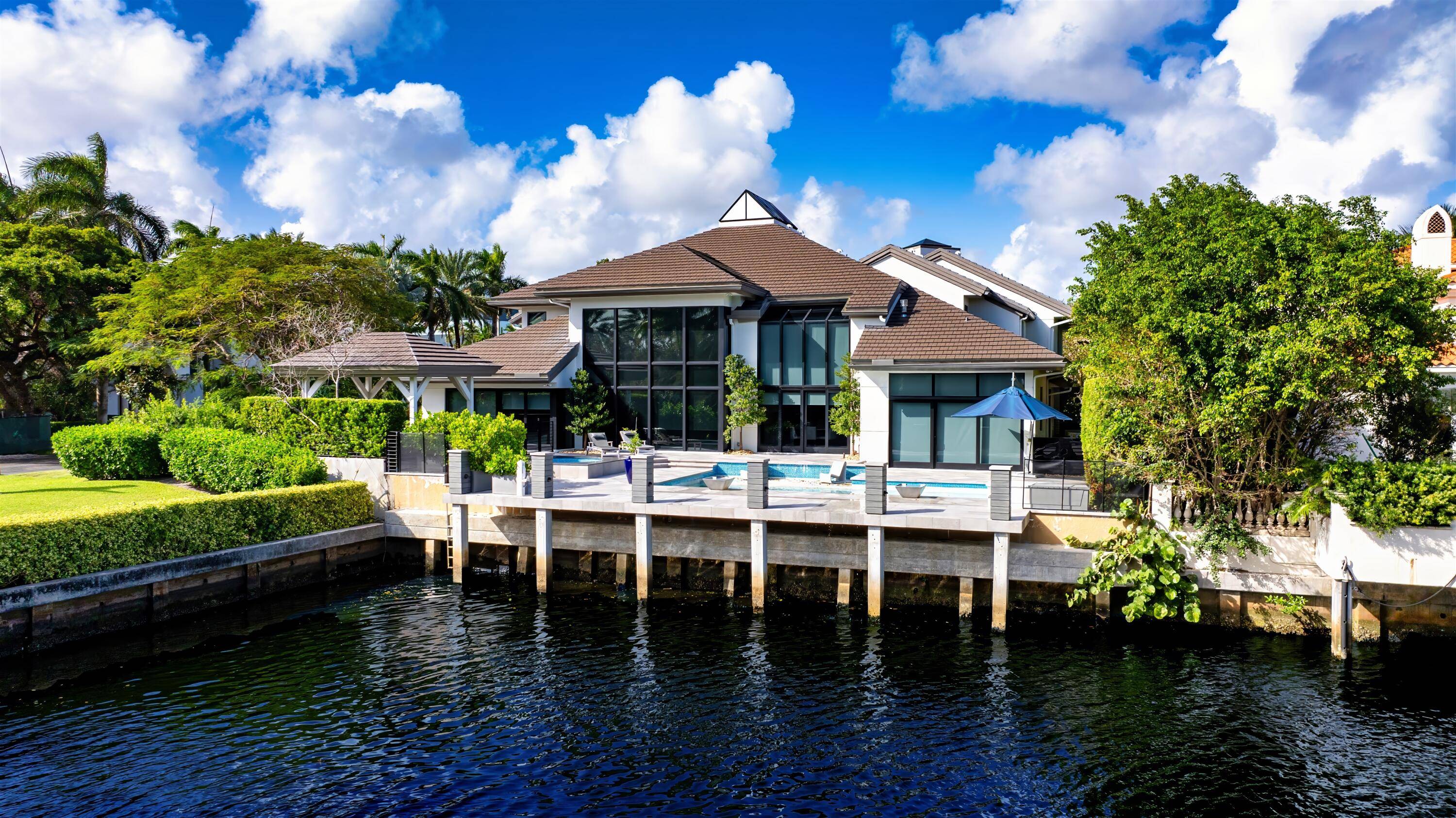 Blending contemporary architecture with lofty urban chic, this dramatic yachting estate offers a voluminous open floor plan with stunning interiors, serene water views, and direct ocean access.