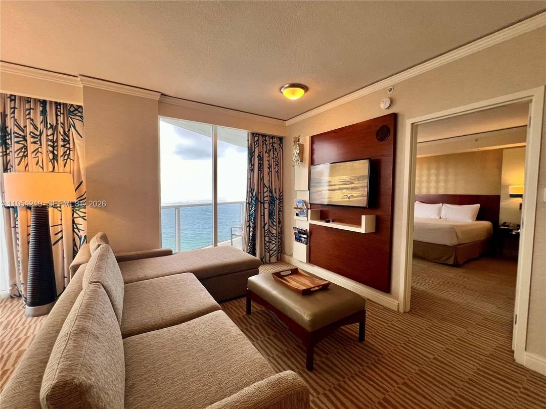 Oceanfront condo hotel residence with over 1, 021 sq ft of interior space and a private balcony offering sweeping views.