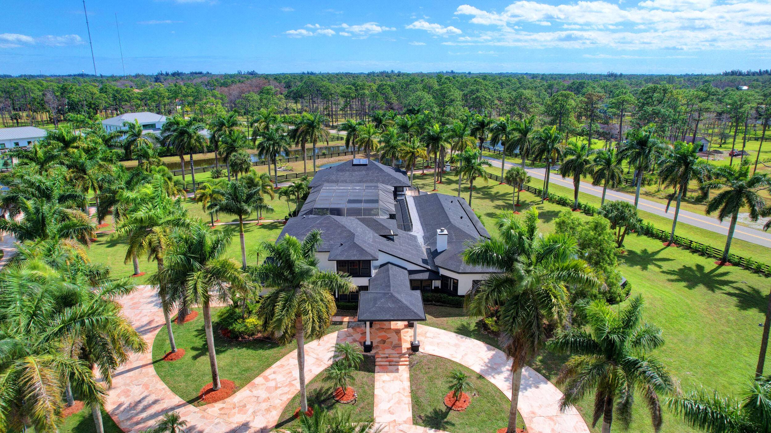 Luxurious Equestrian Estate is situated on 5 plus manicured acres nestled among lush tropical landscape located in the prestigious gated community of Homeland with 24 Hour man security.