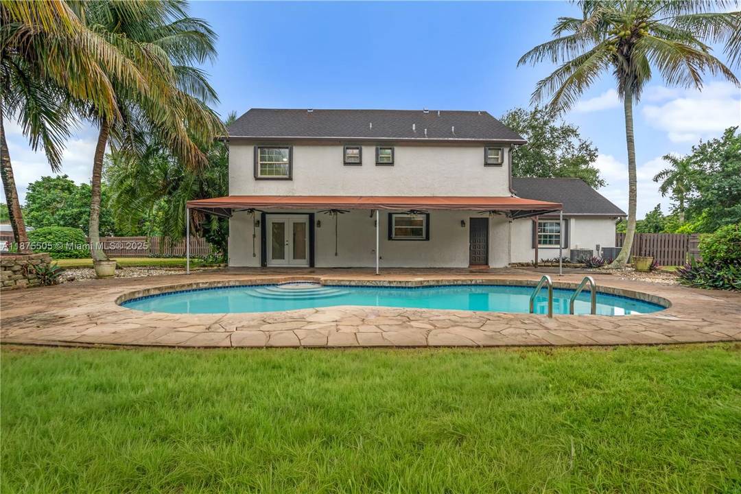 Traditional two story charm meets tropical curb appeal in this spacious 4BD 3.