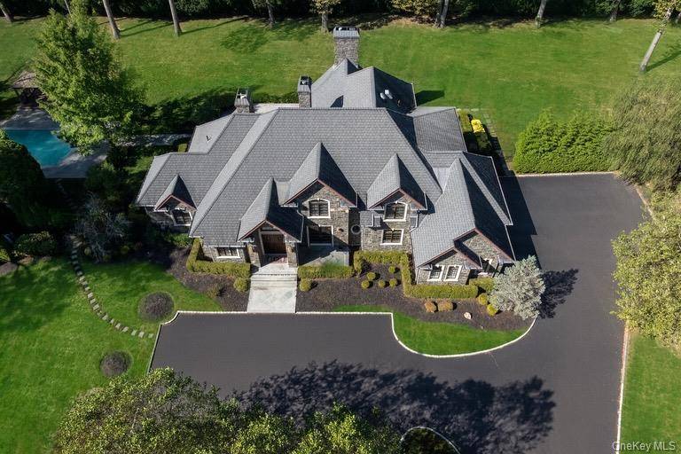 Perfectly situated on over two acres in the heart of Brookville, this stately stone residence combines classic European architecture with modern comfort.