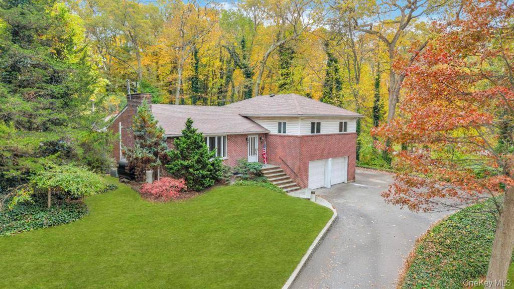 Welcome to 619 Caledonia Road, a well maintained split level ranch set on a private, wooded acre in the heart of Dix Hills.