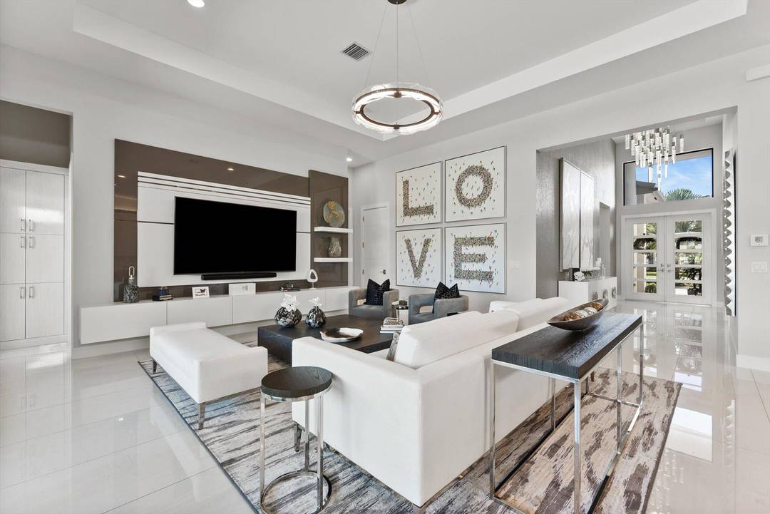 Experience luxury living in Boca Bridges with this stunning coveted corner one story, Murano Contemporary waterfront estate, on nearly half an acre.