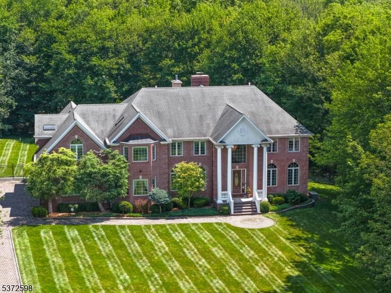 Welcome to Ravenswood, a coveted BASKING RIDGE enclave where mature trees and sweeping lawns set the stage for one of the community's most exceptional homes.
