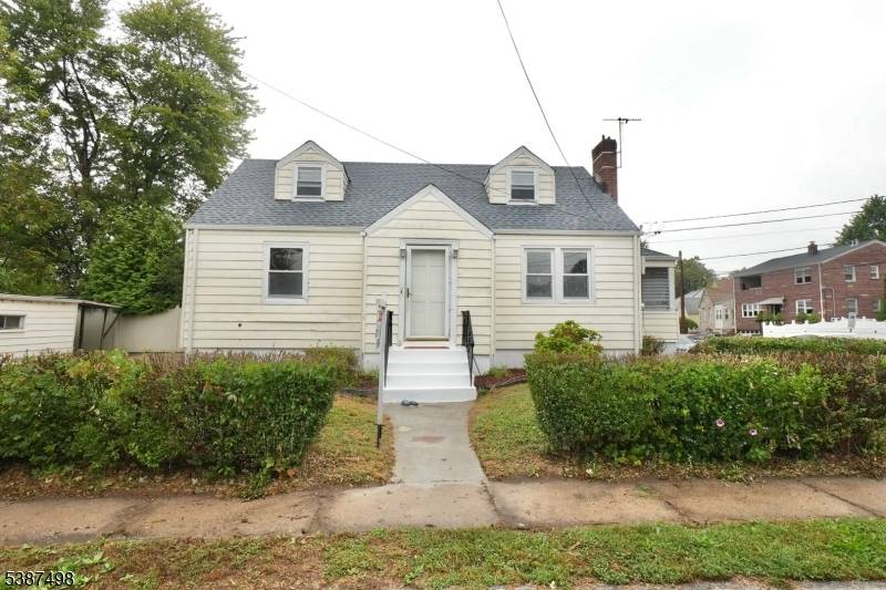 Spacious Cape Cod showcasing a welcoming living room with fireplace, formal dining room, kitchen, and sunroom.
