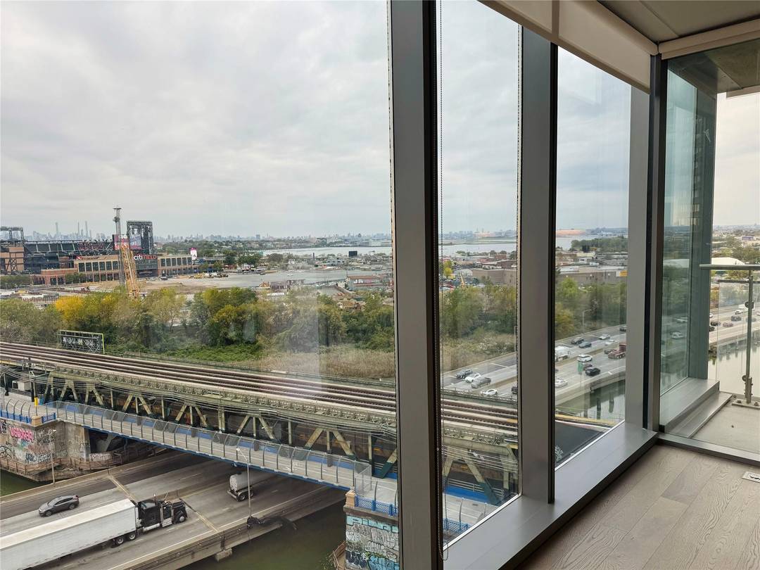 Incredible skyline view with LaGuardia Airport and CitiField across the river and the full NYC cityscape in the background.